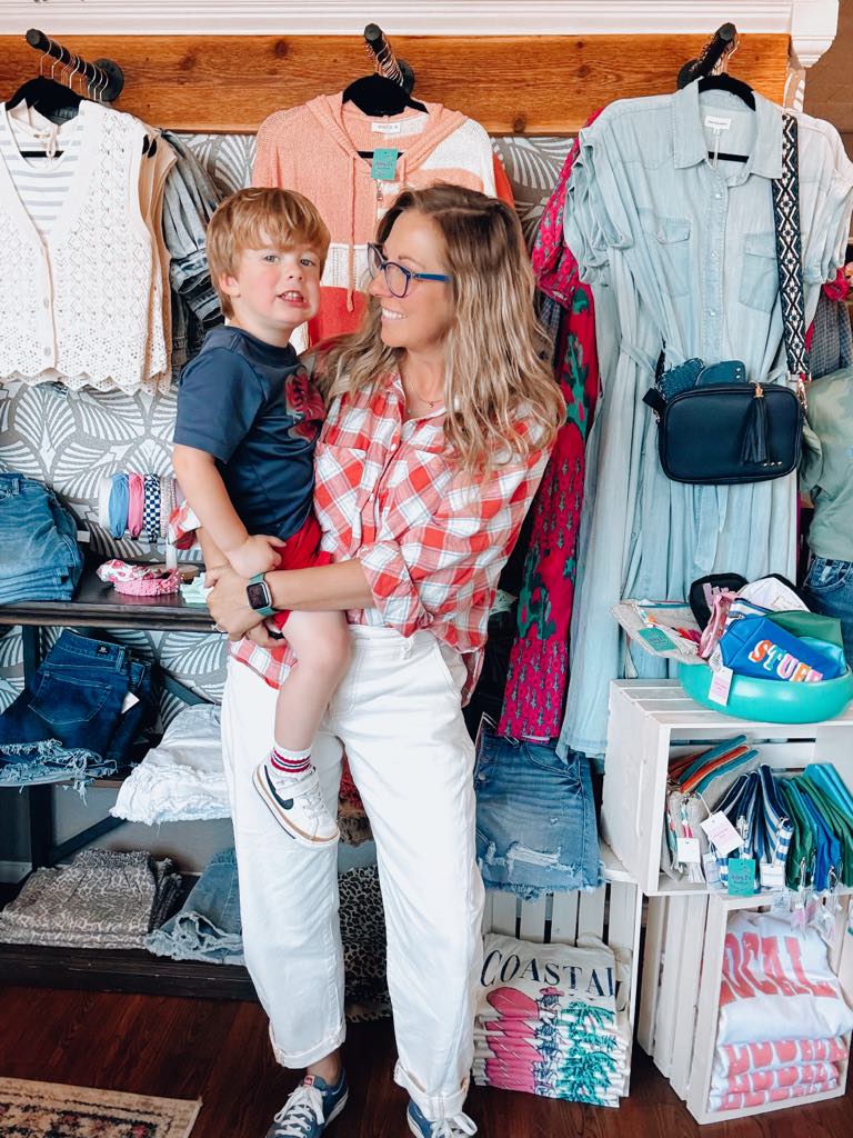 Ashley holding her toddler son and showing you that dressing in what makes you feel good does not have to take a backseat